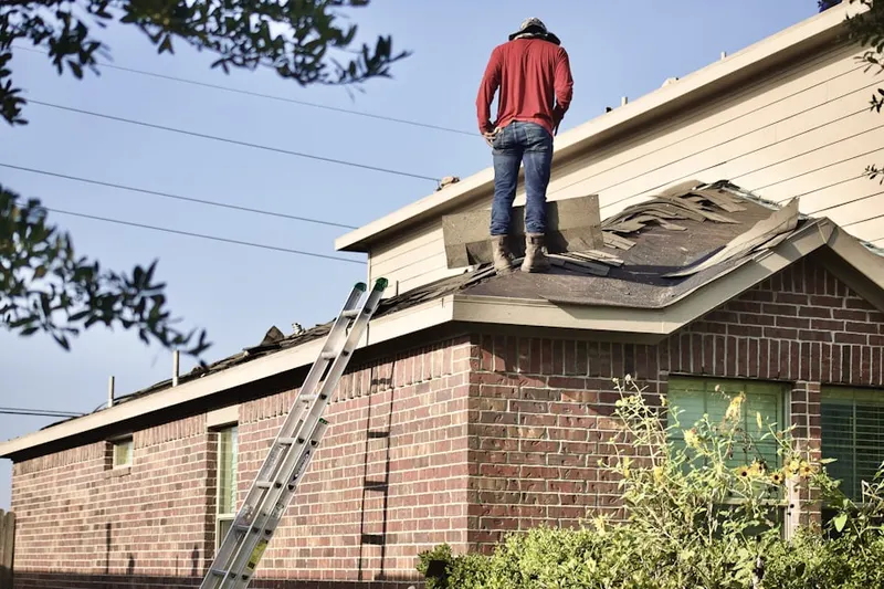 Professional roofer working on a residential roof in Ancor